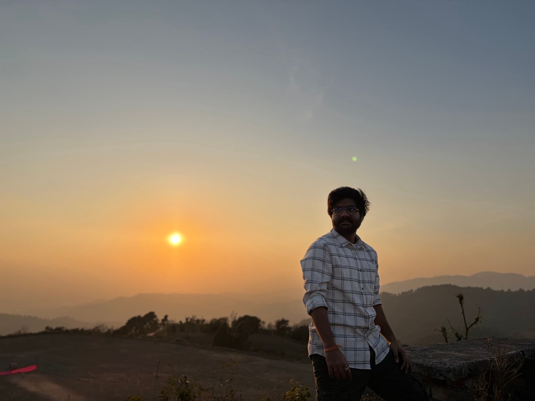 Mohit standing near a sunset in the hills