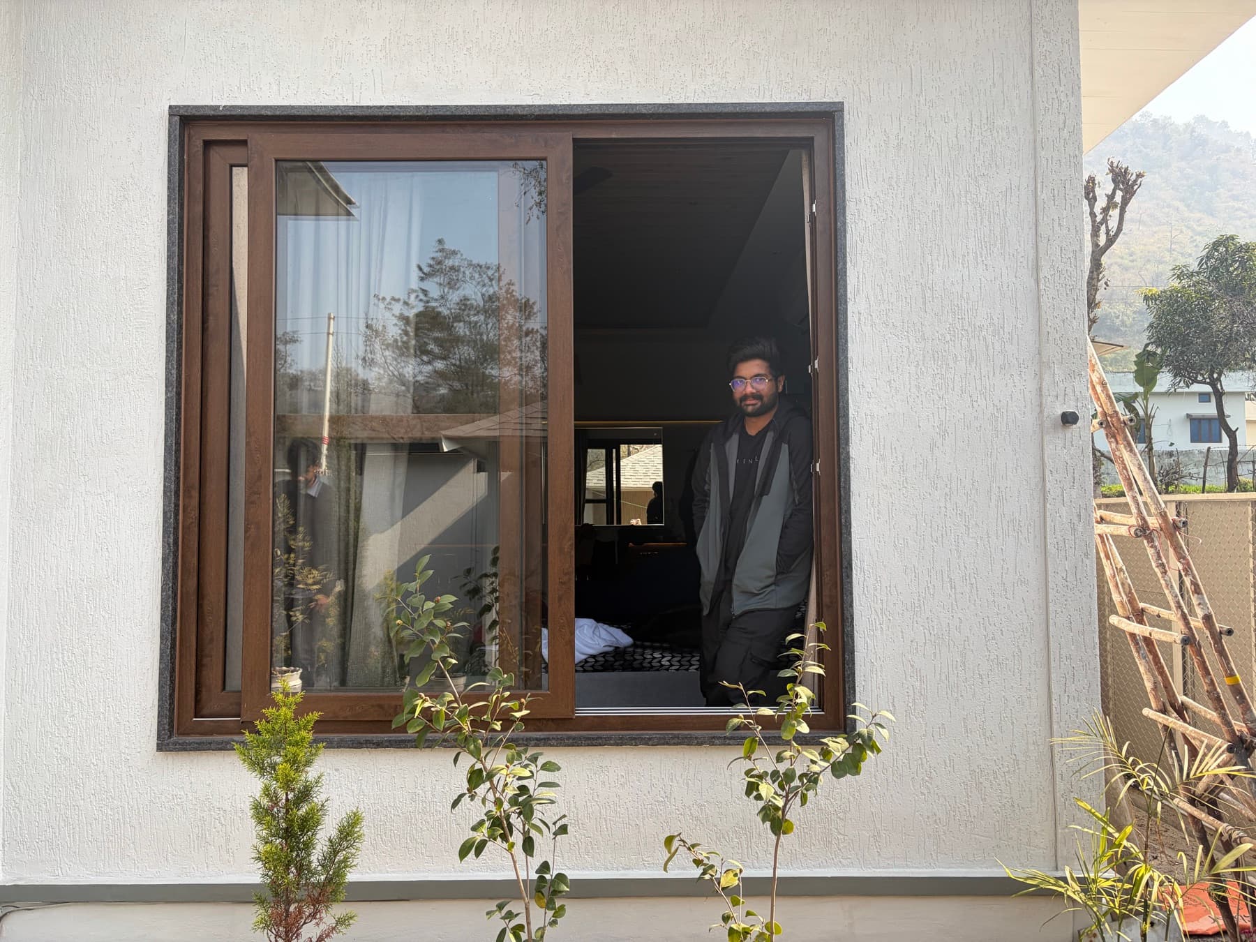 Mohit standing by a window on campus